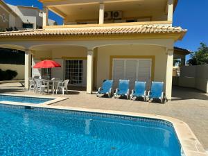 Casa con piscina con sillas y mesa en Benvindo Villa en Albufeira