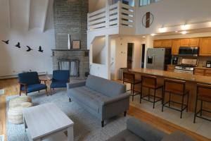 a living room with a couch and a kitchen at Catskills Lakefront Escape with Hot Tub in Monticello