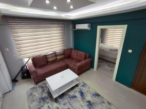 uma sala de estar com um sofá e uma mesa em Çam Suit em Karamamaras