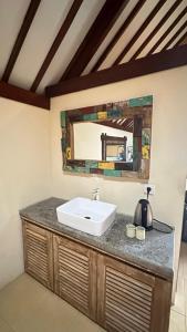 bagno con lavandino e specchio di Bukawa Lodge Jimbaran a Jimbaran