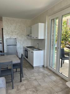 a kitchen with a table and a stove top oven at Villa Colle dei Pini in Cupra Marittima