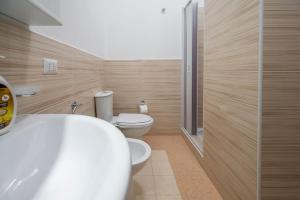 uma casa de banho com um WC, um lavatório e um chuveiro em Avola house orange em Avola