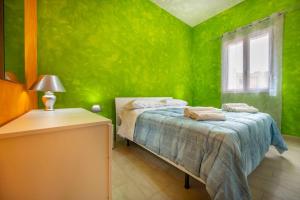 um quarto verde com uma cama e uma janela em Avola house orange em Avola