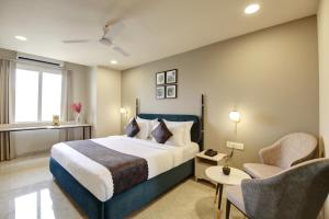 um quarto de hotel com uma cama e duas cadeiras em Saltstayz Horizon - Golf Course Road & Sector 29 em Gurgaon