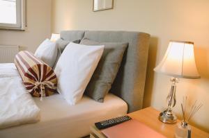una cama con almohadas y una lámpara en una mesa en Apartamenty Agroturystyczne Papiernia en Niedźwiedź