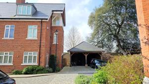 una casa in mattoni con una macchina parcheggiata nel vialetto di Oakdale & The Regal at Fitzroy Gate a Isleworth