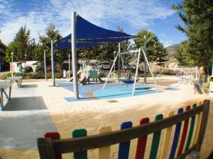 a playground with a blue canopy and a swing at Casa Ladera in Las Lagunas Mijas