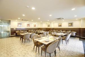 uma sala de jantar com mesas e cadeiras em Saltstayz Horizon - Golf Course Road & Sector 29 em Gurgaon