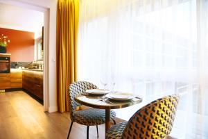 een eettafel met 2 stoelen en een raam bij Business Appart in Tourcoing