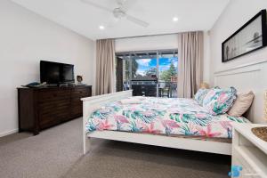 1 dormitorio con 1 cama y TV de pantalla plana en Batemans Bay Apartment, en Batemans Bay