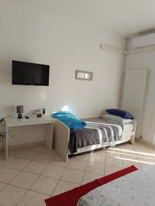 una camera con letto, scrivania e TV di L'appartamento delle vacanze a Venturina Terme