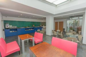 a restaurant with pink chairs and tables in a room at Hotel Adiafa in Barbate