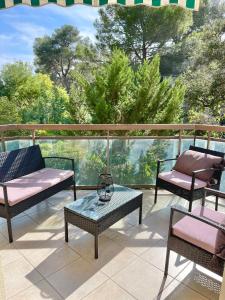 un patio con 3 sillas y una mesa en el balcón en Appartement Plage et Nature, en Saint-Raphaël
