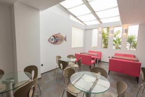 a dining room with tables and chairs and windows at Hotel Adiafa in Barbate