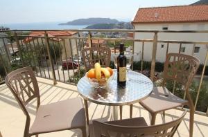 a table with a bottle of wine and bananas on a balcony at Vila Lavandel in Bečići