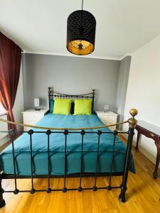 a bedroom with a bed with blue sheets and yellow pillows at 3 bed West Norwood Apartment in West Dulwich