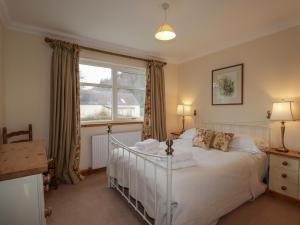 a bedroom with a white bed and a window at Tigh na Drochit in Glenelg