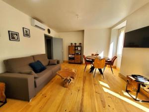 - un salon avec un canapé et une table dans l'établissement Appartement climatisé avec extérieur à Sarlat, à Sarlat-la-Canéda