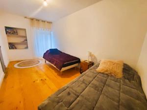 - une chambre avec un grand lit et du parquet dans l'établissement Appartement climatisé avec extérieur à Sarlat, à Sarlat-la-Canéda