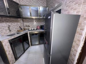 a kitchen with a stainless steel refrigerator and a sink at Welltima Teranga in Dakar