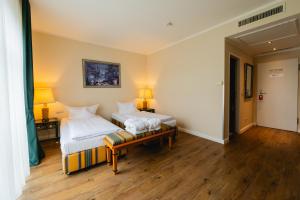 a room with two beds and a table with two lamps at Best Western Wein- und Parkhotel in Nierstein