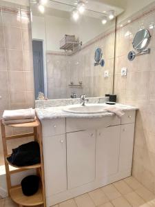 La salle de bains est pourvue d'un lavabo et d'un miroir. dans l'établissement Appartement Plage et Nature, à Saint-Raphaël