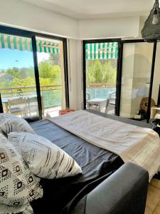 Un dormitorio con una cama grande con almohadas. en Appartement Plage et Nature, en Saint-Raphaël