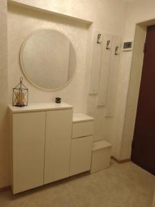 a bathroom with white cabinets and a mirror at Izi's cozy apartment in Kutaisi