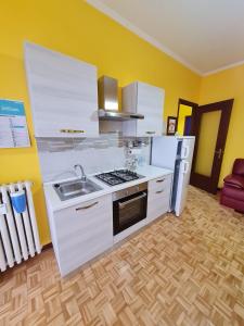 a kitchen with white appliances and yellow walls at Appartamento liliana in Moncalieri