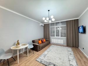 uma sala de estar com um sofá e uma mesa em ЖК "Бухар жырау эксклюзив" Люксовые апартаменты em Astana