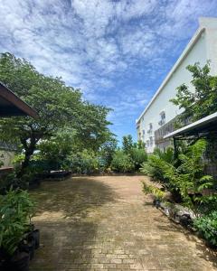 an empty courtyard with trees and a building at Innbox Hostel in Sorong