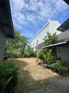 a courtyard of a building with trees and plants at Innbox Hostel in Sorong