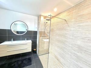 La salle de bains est pourvue d'une douche, d'un lavabo et d'un miroir. dans l'établissement Luxurious cozy house 10 minutes from Charles de Gaulle Airport, à Tremblay-en-France