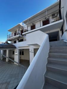 a white building with stairs in front of it at Pansion Angela in Skiathos