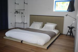a bedroom with a large bed with white pillows at Botel Diffuso dei Laghi in Porto Ceresio