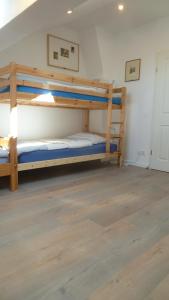 two bunk beds in a room with a wooden floor at Ferienwohnung Dünenblick in Wangerland