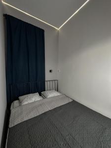 1 dormitorio con 2 camas y cortina azul en YA House, en Budapest