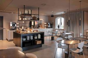Zleep Hotel Køge في كوغ: مطعم فيه طاولات وكراسي في الغرفة