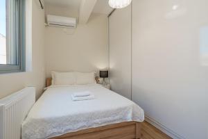 a small bedroom with a bed with two towels on it at Luxury penthouse near Acropolis in Athens