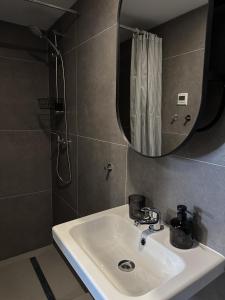 een badkamer met een wastafel en een spiegel bij YA House in Boedapest