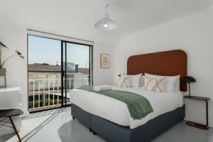Un dormitorio con una cama grande y una ventana grande. en Vernon Terrace 29, en Ciudad del Cabo