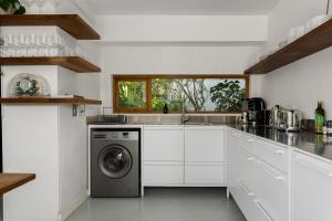 Una cocina blanca con lavadora y secadora. en Vernon Terrace 29, en Ciudad del Cabo 26 fotos más