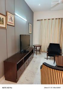 a living room with a flat screen tv on a dresser at Palladium Executive in Islamabad