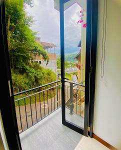 キャンディにある`Kandy Lake Round Apartmentの景色を望むバルコニーへの開放ドア