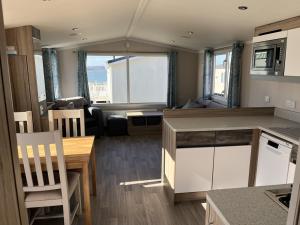 a kitchen and living room with a table and chairs at Rockley Park Private Holiday Homes in Poole