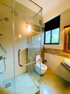 キャンディにある`Kandy Lake Round Apartmentのバスルーム(ガラス張りのシャワー、トイレ付)