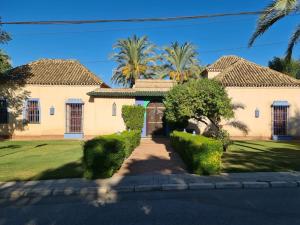a large house with palm trees in front of it at Andalusische Villa in Mairena del Aljarafe