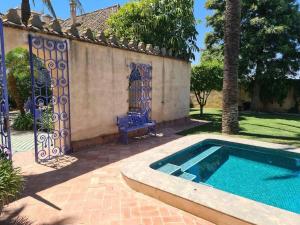 a swimming pool next to a house with a gate at Andalusische Villa in Mairena del Aljarafe