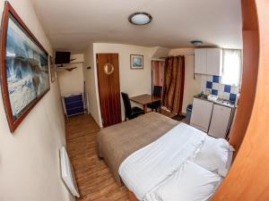 a small room with a bed and a desk at La maison du Lenn face à la mer in Louannec