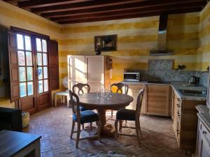 La cuisine est équipée d'une table, de chaises et d'un réfrigérateur. dans l'établissement Andalusische Villa, à Mairena del Aljarafe